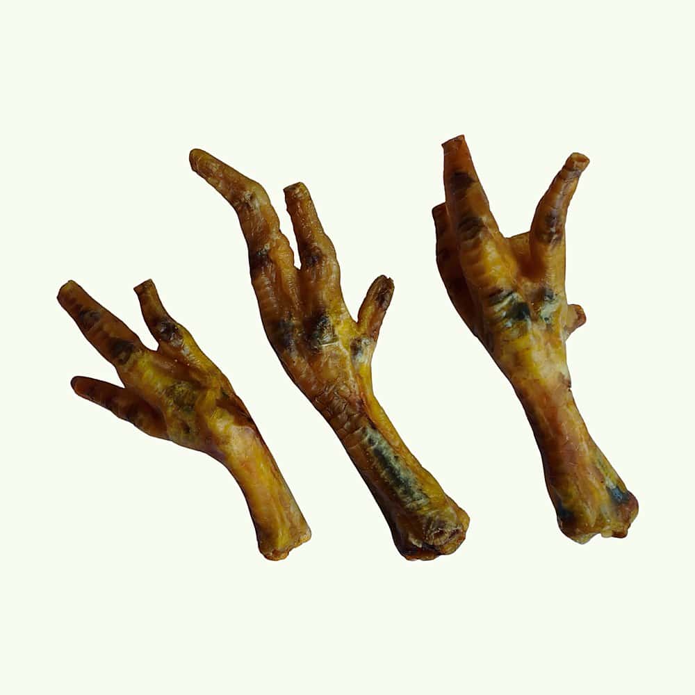 Three dried chicken feet dog treats showing their natural variation in size