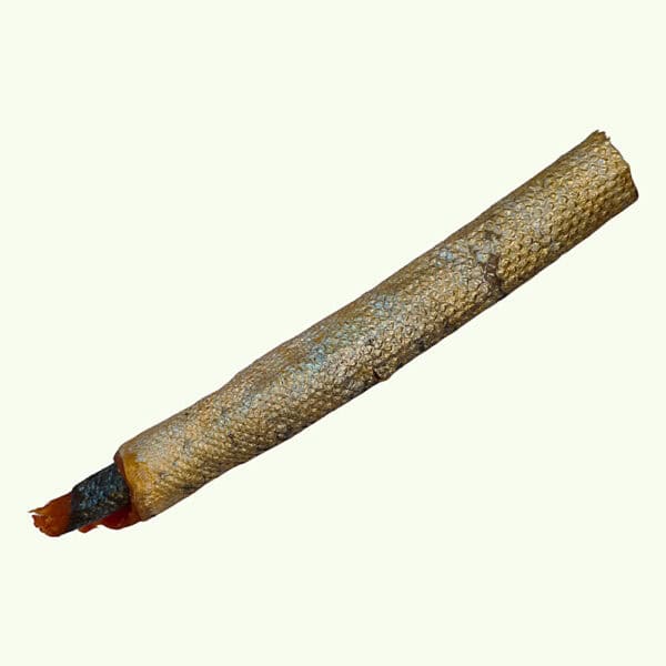 Salmon skin roll dog chew laid on a diagonal, showing the dried scaled skin wrapped into a firm stick
