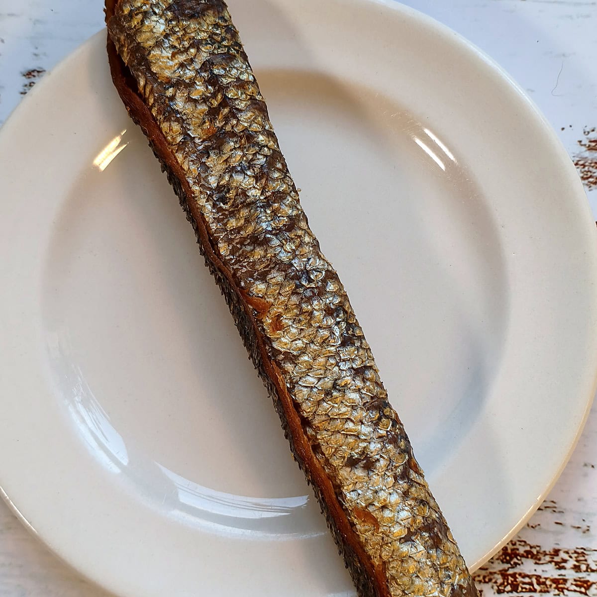 Single salmon skin roll for dogs on a plate