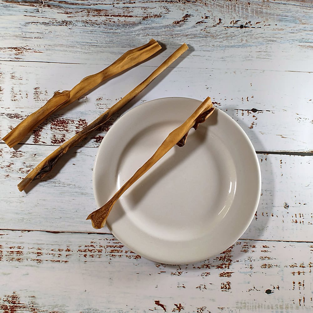 Three natural venison skin chews showing their natural variation in length and thickness
